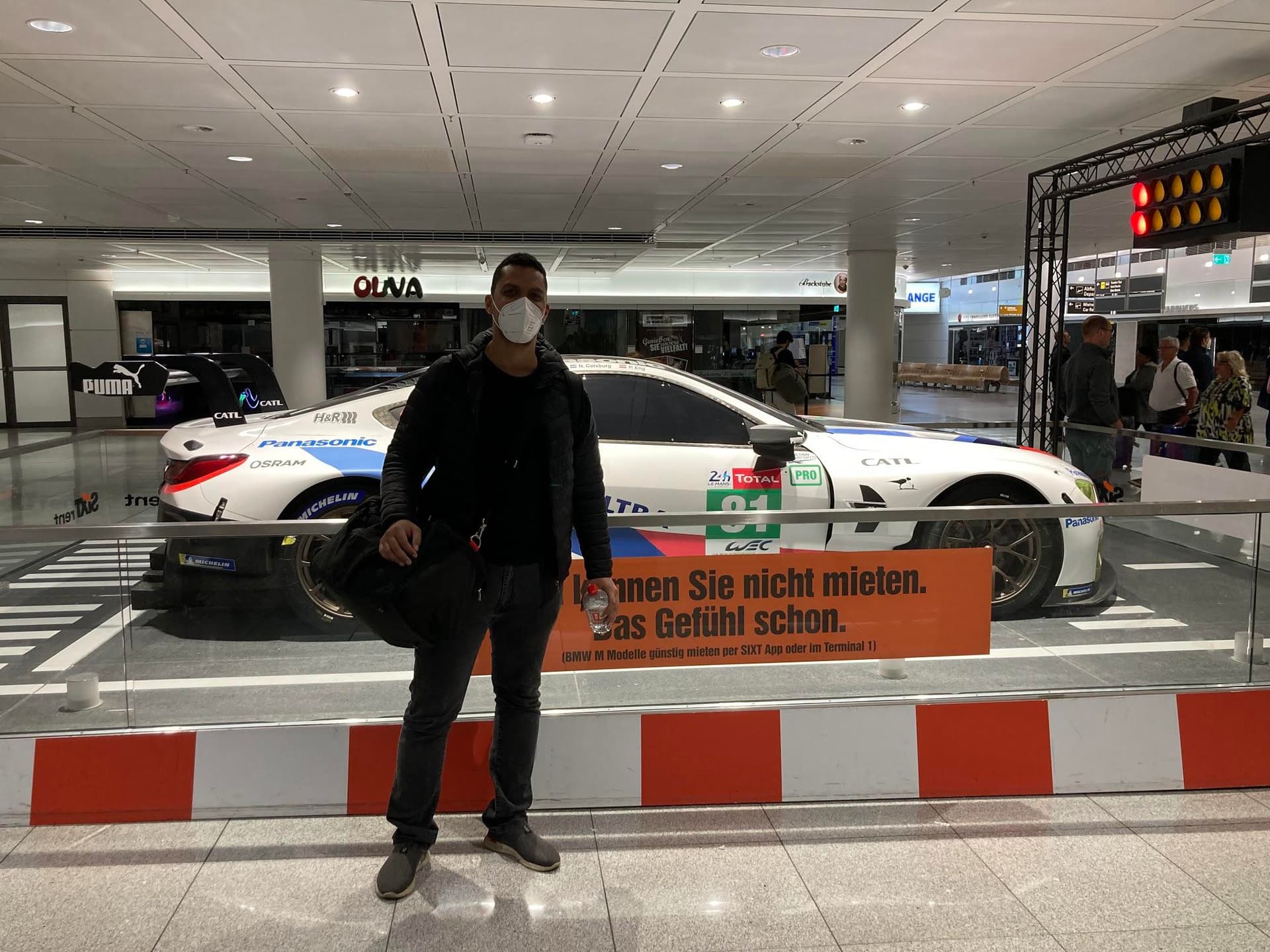 Picture of me posing in front of a race car at Munique's Franz Josef Strauss international airport